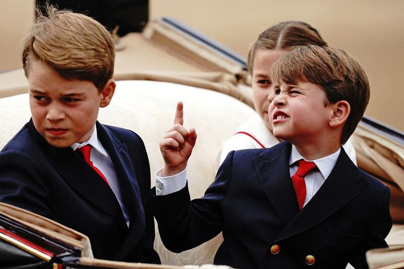 From left, Prince George, Prince Louis and Princess Charlotte ride in a carriage