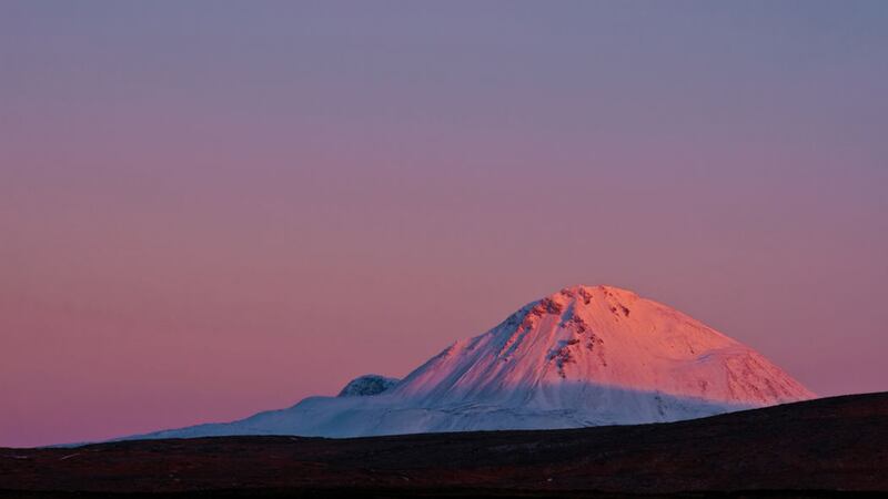 Mount Errigal's quartzite gives off a pinkish glow in the setting sun. Picture by Getty Images
