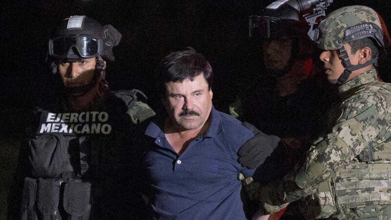 Videos posted on social media have shown one of the daughters of imprisoned drug lord Joaquin &quot;El Chapo&quot; Guzman handing out boxes of rice, pasta, cooking oil and toilet paper with Guzman's image printed on them. El Chapo is seen here being&nbsp;escorted by army soldiers to a waiting helicopter, at a federal hangar in Mexico City last year