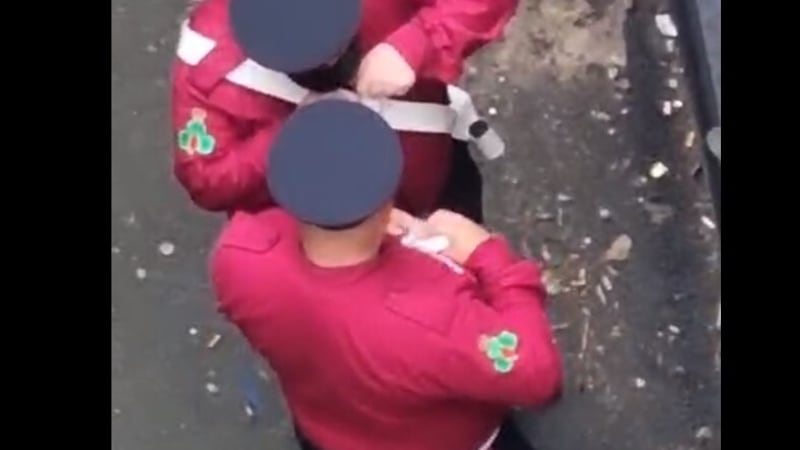 The pair in full band uniform were filmed surreptitiously in a back alley