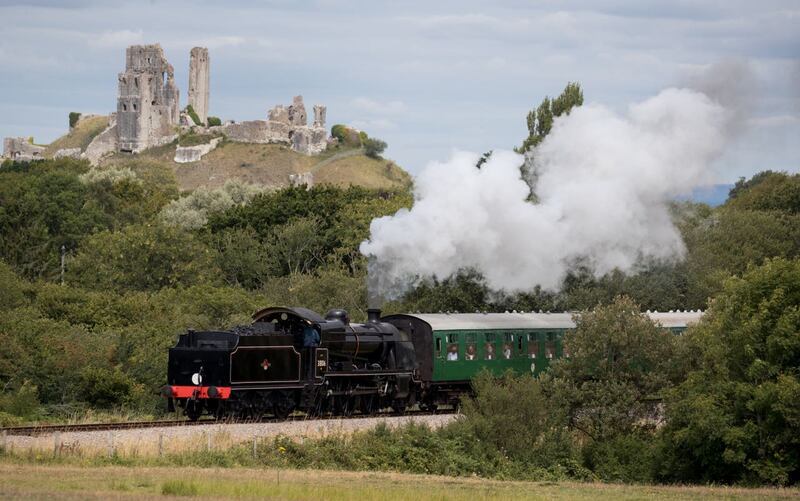 The SR U Class steam locomotive 31806 passes Corfe Castle on the Swanage Railway, as it travels between Norden and Swanage (Andrew Matthews/PA)