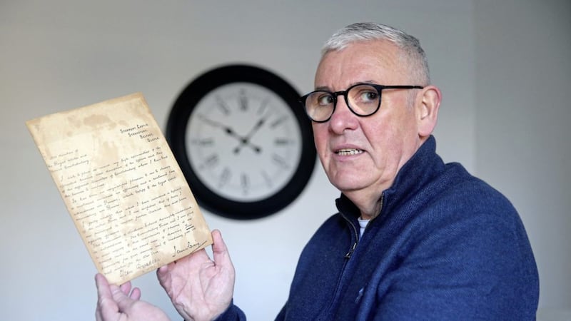 Laurence Kennedy with the letter he found from former  Prime MInster James Craig that was hidden behind a picture of the Sacred Heart. Picture by Mal McCann