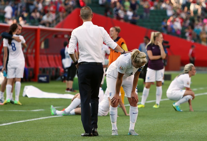 England's head coach Mark Sampson consoles his players after defeat at the 2015 World Cup against Japan