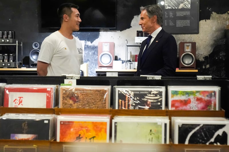 Antony Blinken talks to Yuxuan Zhou during a visit to Li-Pi record store in Beijing (Mark Schiefelbein/AP)