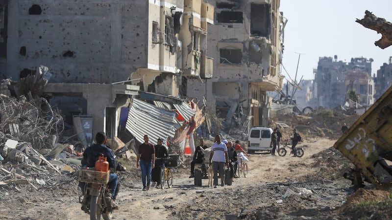 Palestinians walk through the destruction left by the Israeli air and ground offensive after they withdrew from Khan Younis, southern Gaza Strip (Ismael Abu Dayyah/AP)