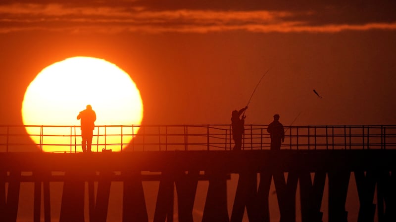 Fishermen land mackerel as the sun rises behind Blyth pier in Northumberland (Owen Humphreys/PA)