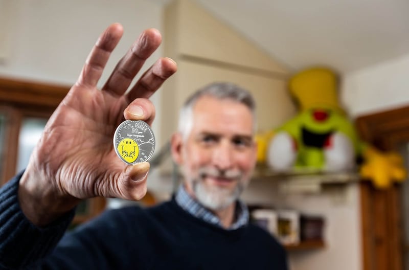 Adam Hargreaves holds a Mr Happy coin