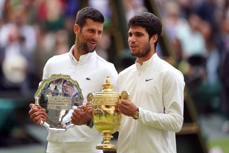 Djokovic and Alcaraz holding their trophies