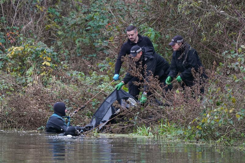 Police search teams pull a black bag from the River Wensum on Friday