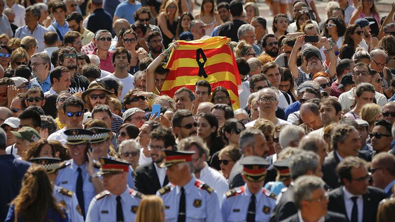 People holding a Catalan flag gather for a minute of silence in memory of the terrorist attacks victims in Las Ramblas, Barcelona, Spain, Friday, Aug. 18, 2017&nbsp;