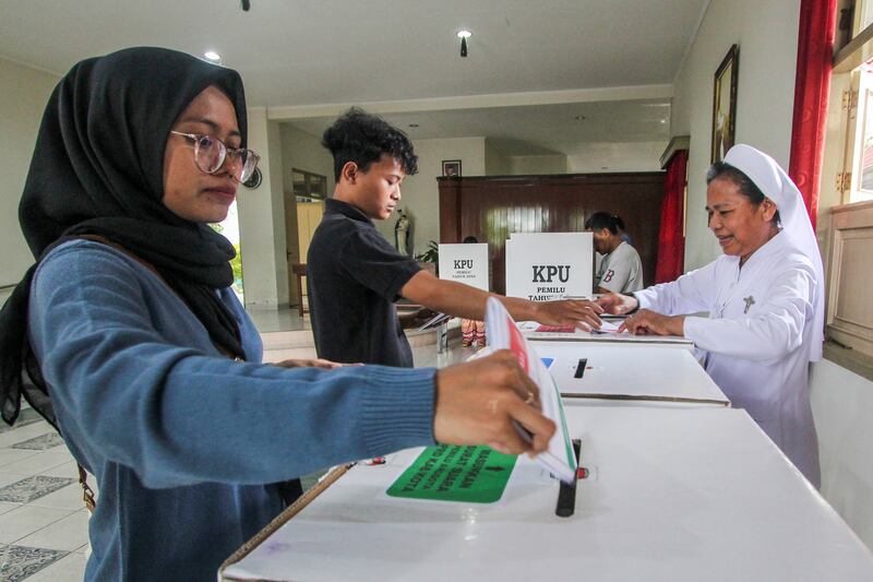A Catholic nun helps voters to cast their ballots at a convent turned into polling station in Yogyakarta (AP)
