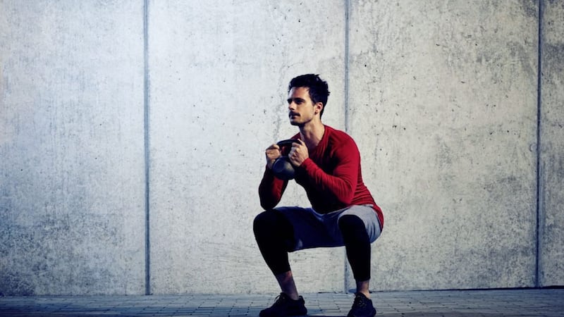 Doing a goblet squat with a kettlebell 
