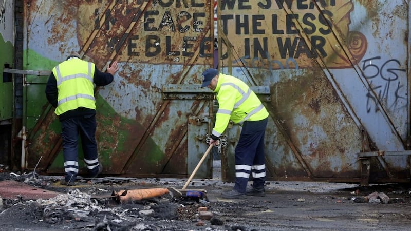 Council workers clean up after a night of rioting at the interface on Lanark Way. Picture by Mal McCann 