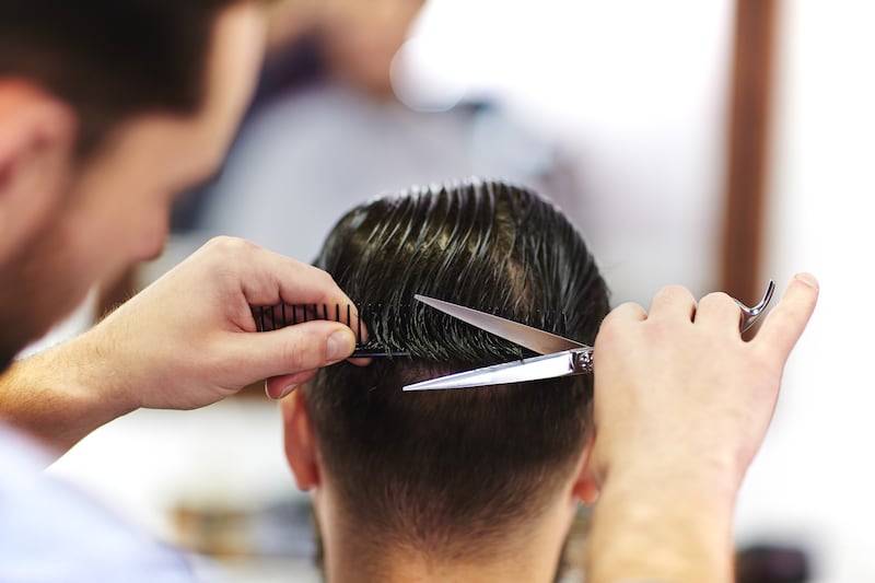 A man gets his hair cut by a barber