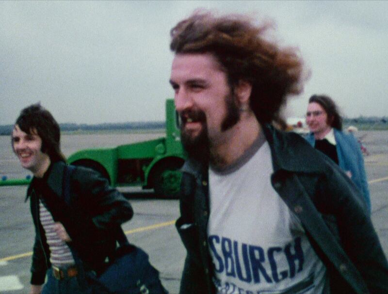 Billy Connolly at an airport in 1975 in a scene from the tour film Big Banana Feet