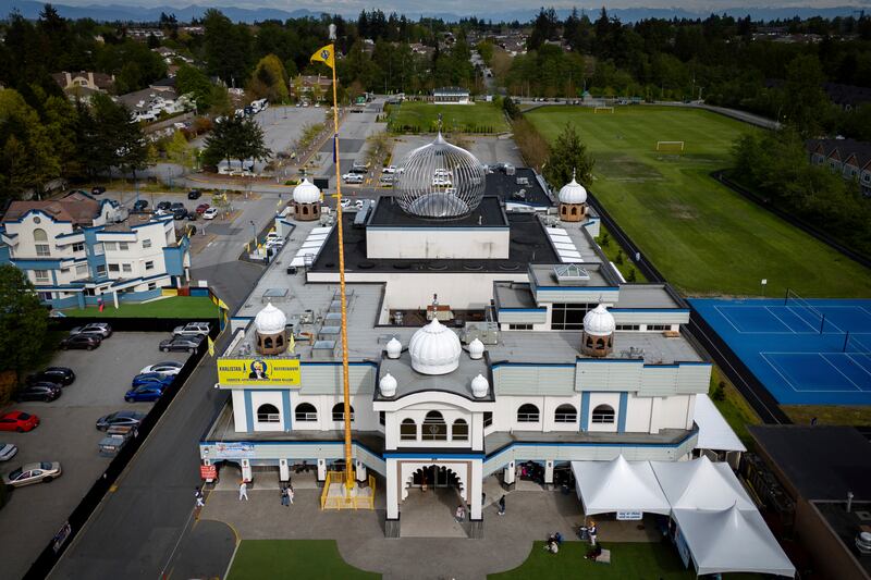 In this photograph taken with a drone, people sit on the front lawn of the Guru Nanak Sikh Gurdwara, in Surrey, British Columbia (Ethan Cairns/AP)