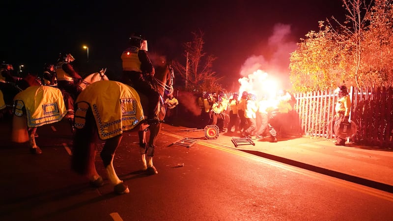 Police attempt to put out flares that have been thrown towards them outside the stadium before the UEFA Europa Conference League Group E match at Villa Park, Birmingham (David Davies/PA)