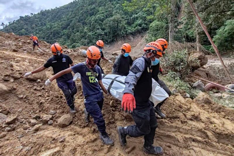 Rescuers recover a body from the landslide-hit village (Municipality of Monkayo via AP)