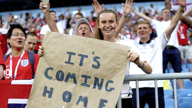 An England fan holds up an &#39;It&#39;s Coming Home&#39; banner during the quarter final match with Sweden. An England World Cup win could boost the UK economy, according to some economists 