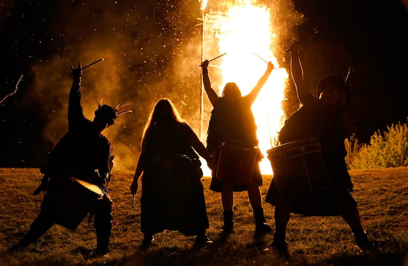 Members of the Pentacle Drummers perform in front of a burning wicker man during the Beltain Festival at Butser Ancient Farm, in Waterlooville, Hampshire in April 