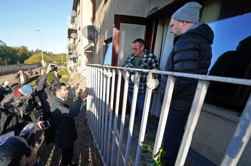 Humza Yousaf speaking to Brechin resident on a balcony about impacts of flooding