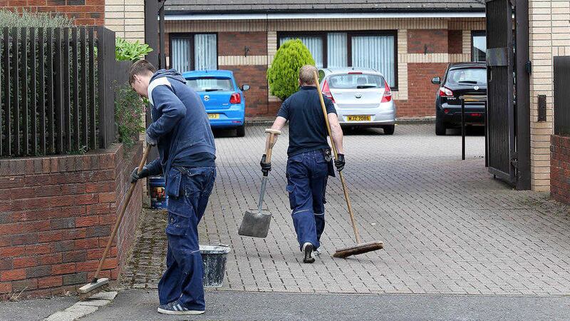 Workers clearing up the mess left outside a care home on Belfast&#39;s Woodvale Road. Picture by Mal McCann 