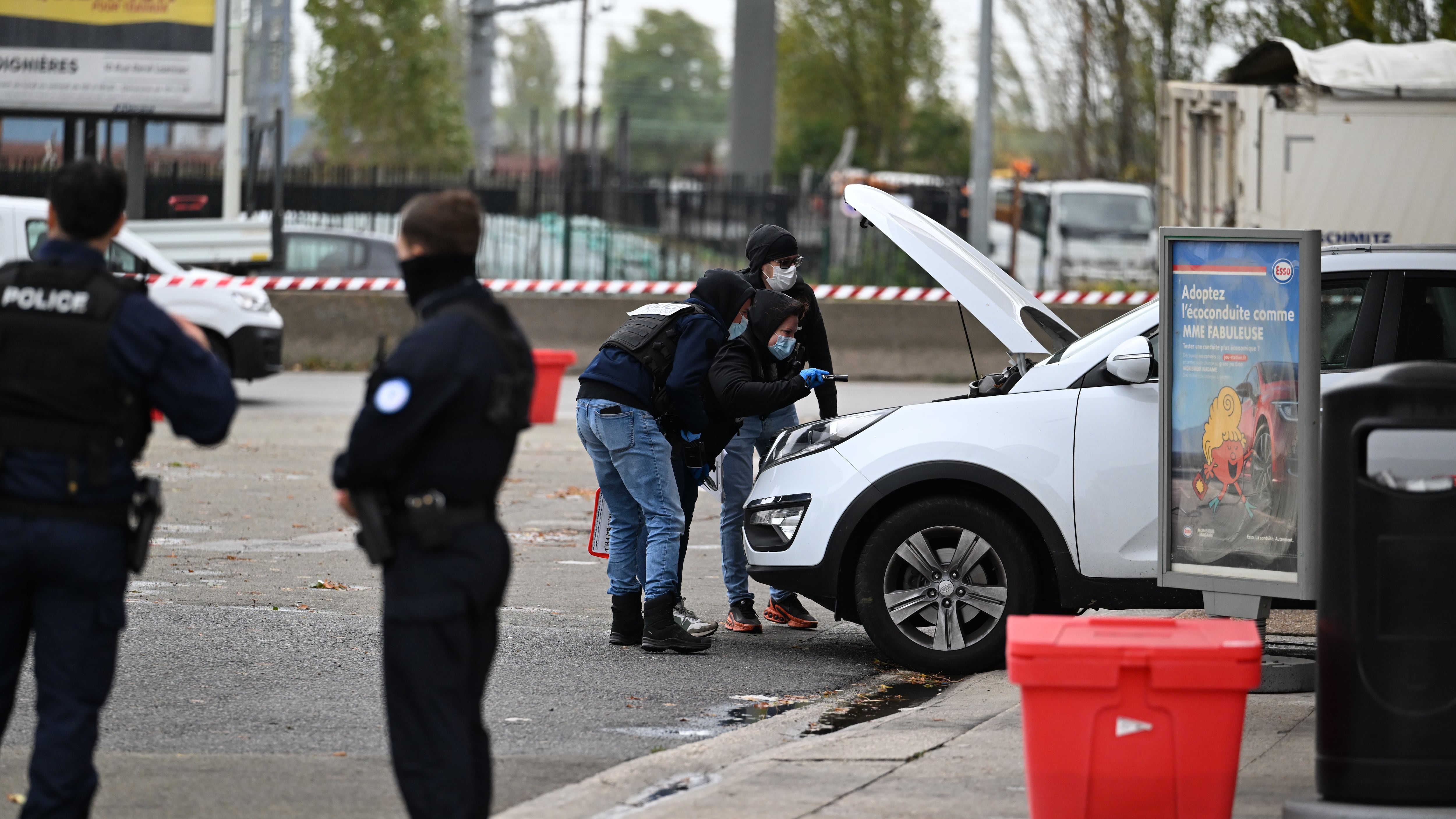 Police search a car at a petrol station after a shooting in Trappes, outside Paris (Emma Da Silva/AP)