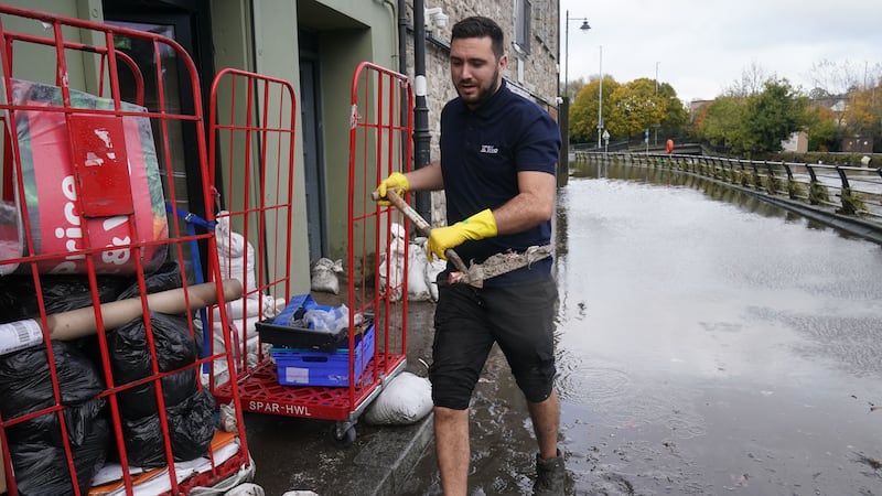 Ross Campbell clears out a damaged property in Newry, Co Down, after the city’s canal burst its banks during heavy rainfall (Brian Lawless/PA)