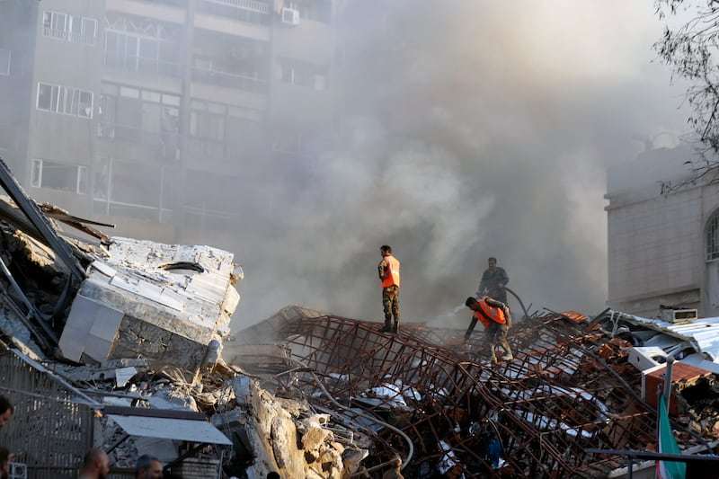 Emergency services at the destroyed building (Omar Sanadiki/AP)