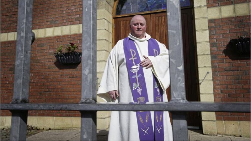 Fr Paddy McCafferty behind the locked gates of Corpus Christi Church in Ballymurphy. Picture by Hugh Russell 