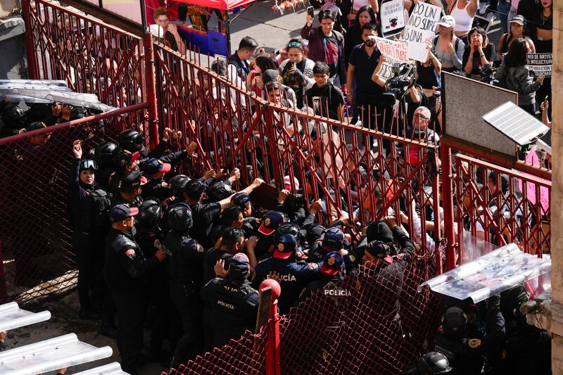 Police block a gate as animal rights activists try to enter the Plaza Mexico (AP)