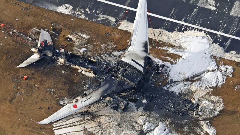 The burnt-out Japan Airlines plane at Haneda airport (Kyodo News via AP, File)