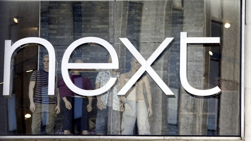 Fashion chain Next has cut its annual profit forecast and predicted falling earnings over the year ahead 