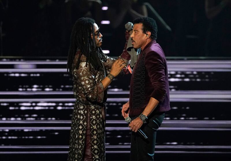 Lenny Kravitz, left, dabs inductee Lionel Richie with a cloth after his performance during the Rock & Roll Hall of Fame Induction Ceremony at the Microsoft Theatre in Los Angeles