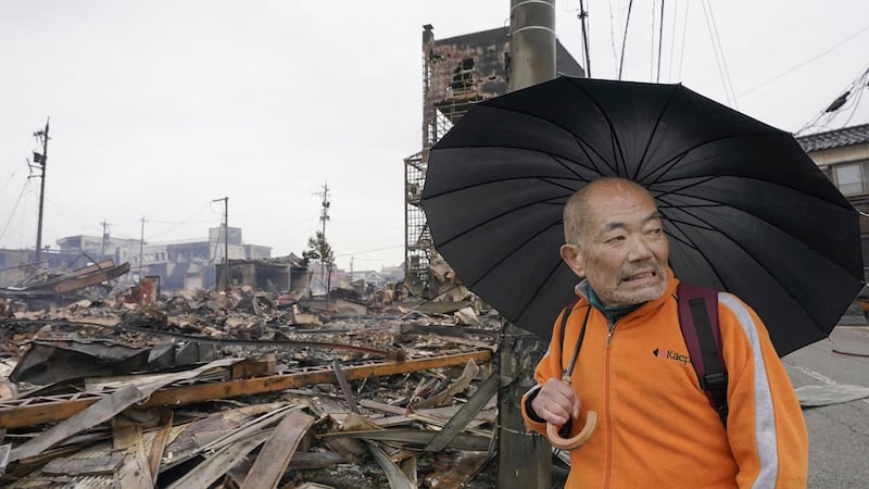 A man looks at the burnt area hit by a fire, following earthquakes in Wajima, Ishikawa prefecture, Japan (Kyodo News via AP)