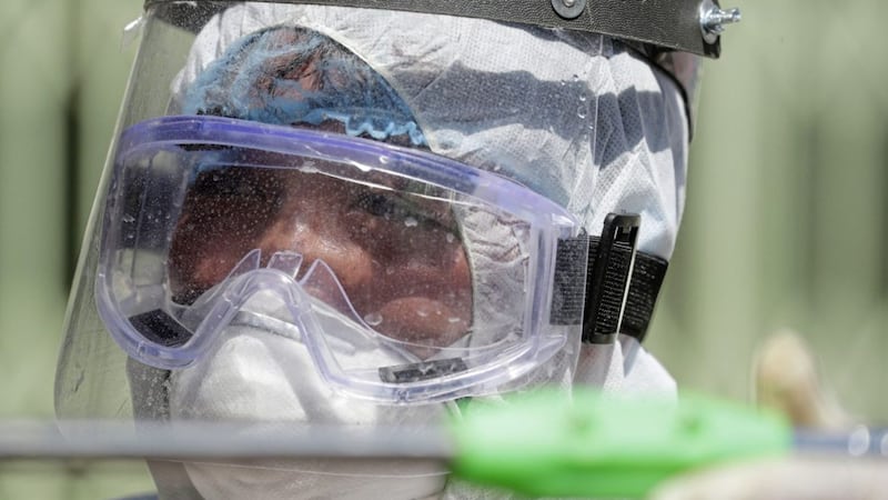 A worker in protective suit disinfects a school which has suspended classes as a precautionary measure against a new coronavirus in the Philippines 