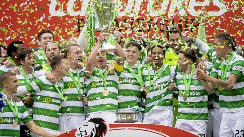Celtic skipper Scott Brown hoists the Ladbrokes Premiership trophy aloft after his side defeated Hearts 2-0 at Parkhead yesterday to complete the league season unbeaten Picture: PA 