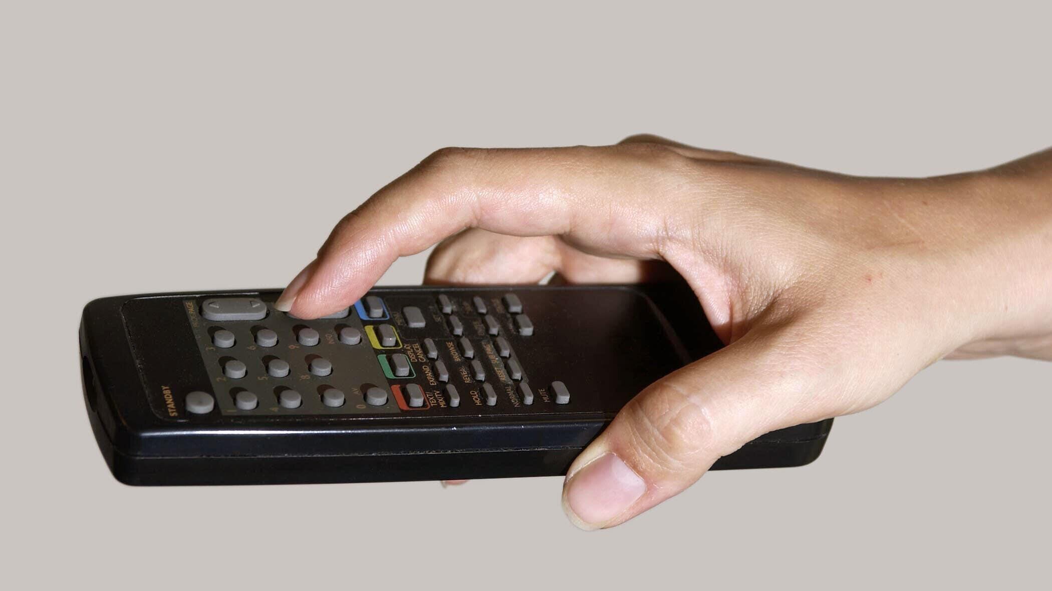 A hand holding a television remote control (Myung Jung Kim/PA)