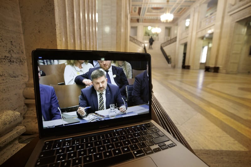 A laptop screen in the Great Hall at Parliament Buildings at Stormont shows a live feed of Minister for Health Robin Swann giving evidence to his scrutiny committee