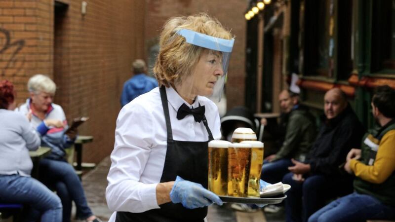 A staff member wearing a visor while serving pints at the Morning Star in central Belfast. Picture by Mal McCann 