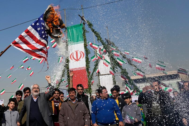 Demonstrators in Tehran burn a US flag during their annual rally commemorating Iran’s 1979 Islamic Revolution (Vahid Salemi/AP)