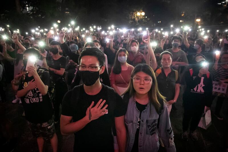 Demonstrators hold their phones aloft as they sing Glory To Hong Kong during a rally in 2019