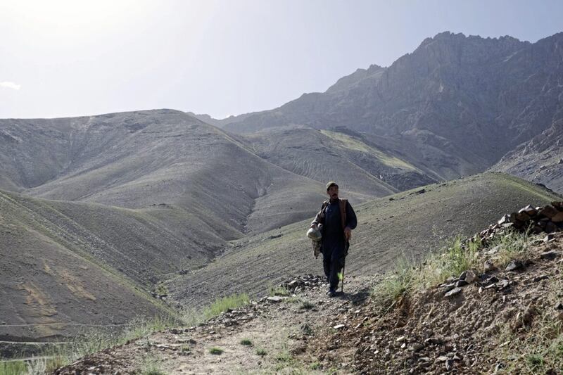 A 56-year-old man walks with the help of a cane in Daykundi Province, Afghanistan, on May 28 