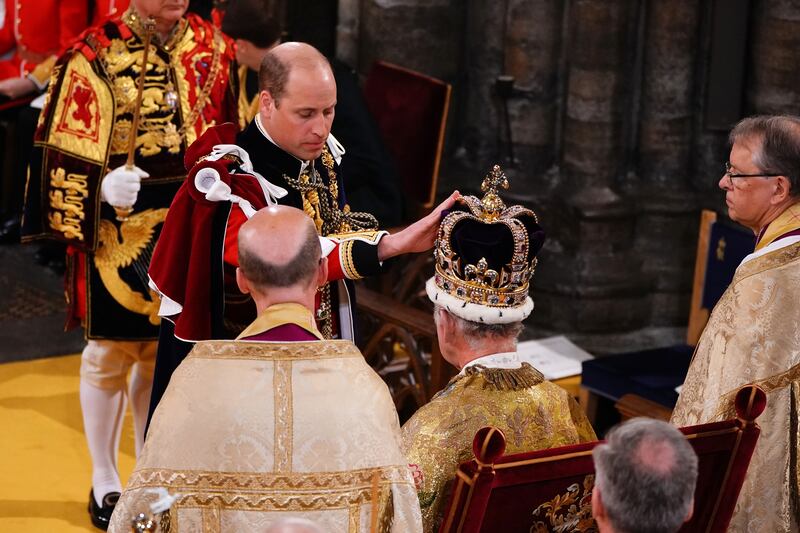 The Prince of Wales touches St Edward’s Crown on Charles’s head during the coronation