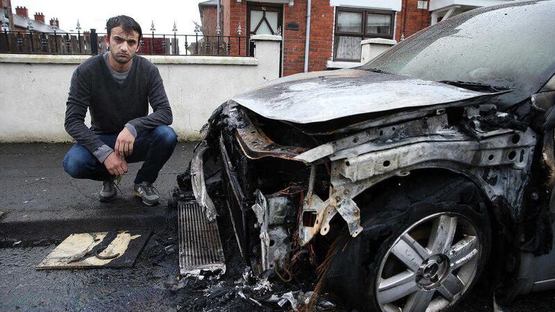 Daniel Cirpaci beside his car that was burnt out in Ebor Street, south Belfast, in a racist attack. Picture by Mal McCann 