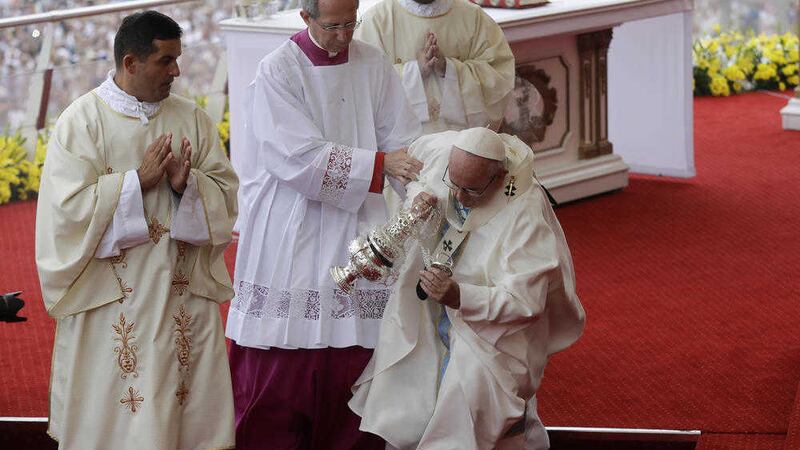 Pope Francis is helped by Vatican Master of Ceremonies, Mons. Guido Marini as he stumbles on the altar at Czestochowa, Poland. Picture by Gregorio Borgia, Associated Press 