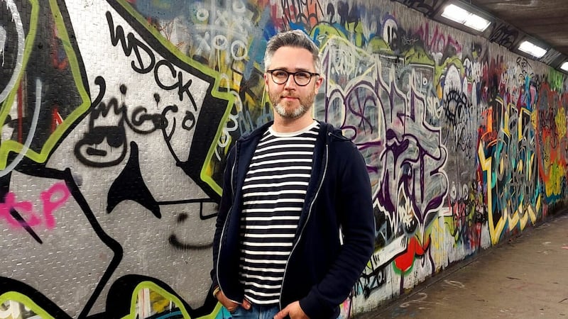 SDLP councillor Gary McKeown pictured in front of some of Belfast's street art. The council has now passed his plan to introduce legal graffiti walls in the city in a bid to cut down on unwanted vandalism and promote local artists.