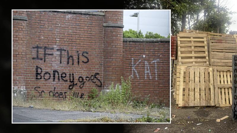 Pallets being stored at Tigers Bay in north Belfast, and inset, graffiti at the Duncairn Gardens interface 