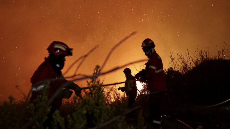 Firefighters battle a wild fire raging near houses in the outskirts of Obidos, Portugal PICTURE: Armando Franca/AP 