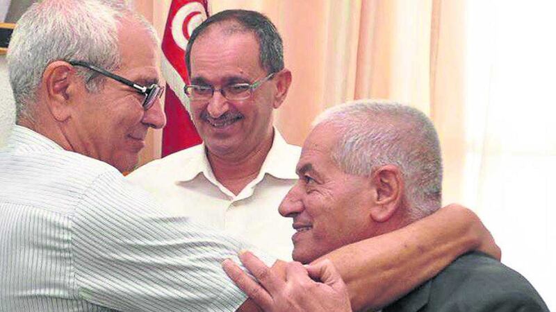 Houcine Abassi, secretary general of the Tunisian General Labour Union (UGTT), right, is congratulated by unidentified union members in his office at the headquarters in Tunis, Tunisia, Friday, Oct. 9, 2015. Abassi is one of the four members of the Tunisian National Dialogue Quartet to be awarded the 2015 Nobel Peace Prize on Friday by the Norwegian Nobel Committee. (AP Photo) 